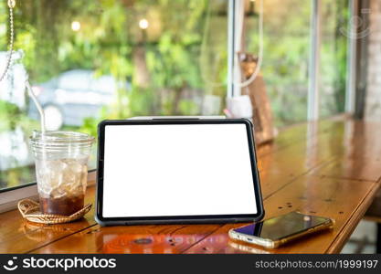 Mockup of digital tablet with empty screen with coffee and smartphone isolate on wooden office desk in coffee shop like the background ,White screen