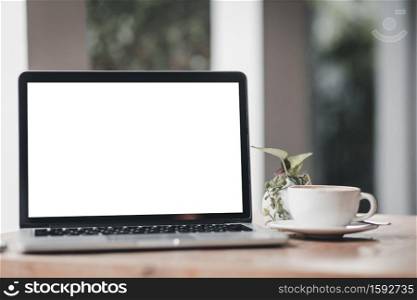 Mockup of laptop computer with empty screen with coffee cup on table of the coffee shop background,White screen