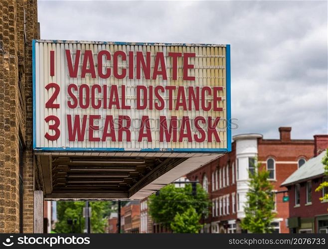 Mockup of movie cinema billboard with vaccinate, wear a mask, social distance to deal with the omicron variant of Covid-19 coronavirus epidemic. Mockup of recommendations to avoid Omicron variant on cinema marquee board