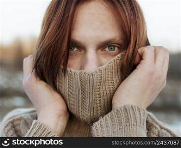 model covering face with beige sweater 2