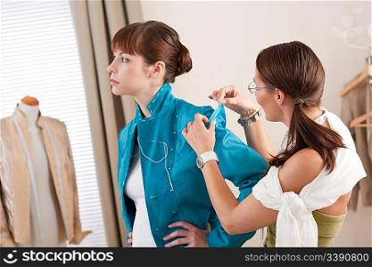 Model fitting by professional female fashion designer studio