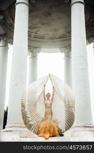 model girl dress gold angel posing in the woods near the old columns