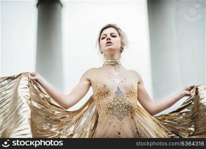 model girl dress gold angel posing in the woods near the old columns