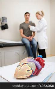 Model heart and patient being examined
