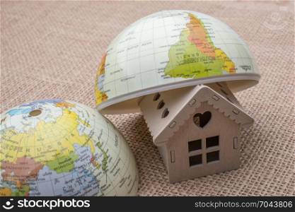 Model house and a globe on a linen canvas