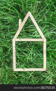 Model house made of wooden sticks on green grass