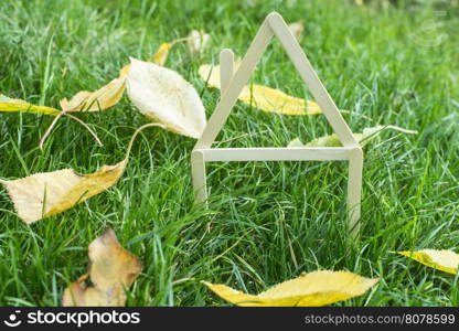 Model house made of wooden sticks on green grass