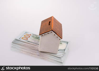 Model house placed on the American dollar banknotes on white background