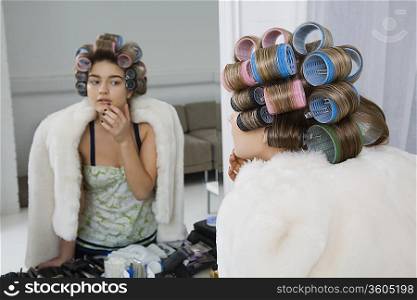 Model in Hair Curlers Looking at Reflection