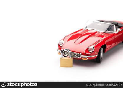 Model of a red car with padlock in front of it on white background. Concept of security. Close up, copy space, selective focus.