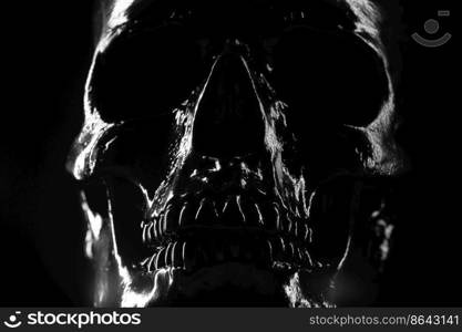 Model of human skull painted with black on dark background with illumination. Concept of fear and horror, Halloween celebration. Copy space.. Model of human skull painted with black on dark background with illumination. Concept of fear and horror, Halloween celebration. Copy space