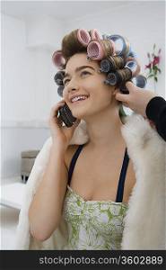 Model on Cell Phone While Having Hair Curled