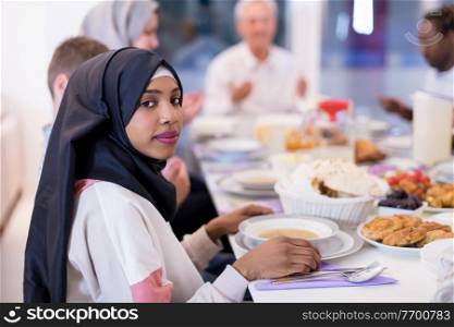 modern african american muslim woman enjoying iftar dinner together with multiethnic family during a ramadan feast at home