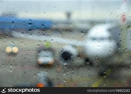 Modern airport in rainy weather. View of the parked plane through the fogged glass. Modern Airport in Rainy Weather