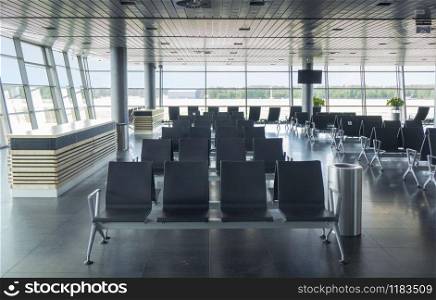 Modern airport terminal with empty arm-chairs for waiting departure. Travel and transportation concept.. Empty waiting hall in airport with lounge area.
