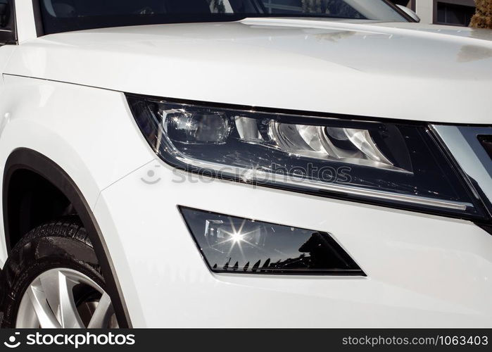 modern and elegant white car - Closeup of car headlight with copy space. white car headlight. modern and elegant white car - Closeup of car headlight with copy space. white car headlight.