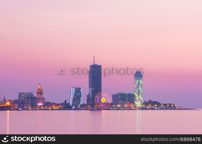 Modern Batumi at sunset, Adjara, Georgia. View from Sea Beach to Illuminated cityscape with Skyscrapers And Tower at sunset, Batumi, Adjara, Georgia