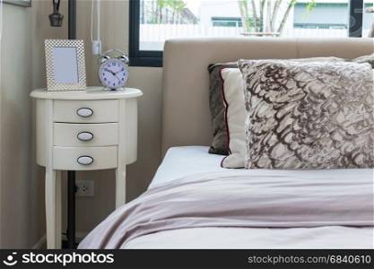 modern bedroom design with bed, pillows and lamp on table