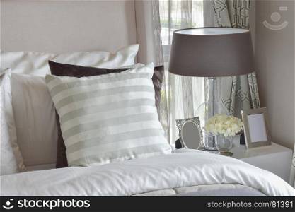 modern bedroom interior with green striped pillow on bed and bedside table lamp at home