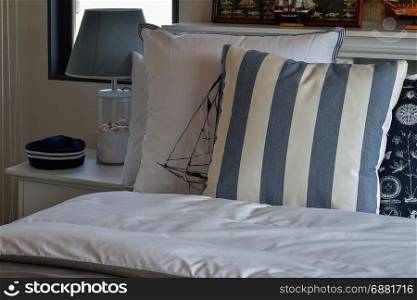 modern bedroom interior with green striped pillow on bed and decorative table lamp at home