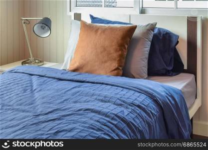 modern bedroom with brown pillows on blue bed