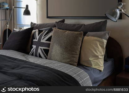 modern bedroom with gray pillow and lamp on wooden bedside table at home