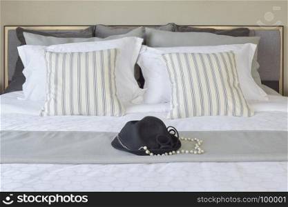 modern bedroom with striped pillows and black hat on bed