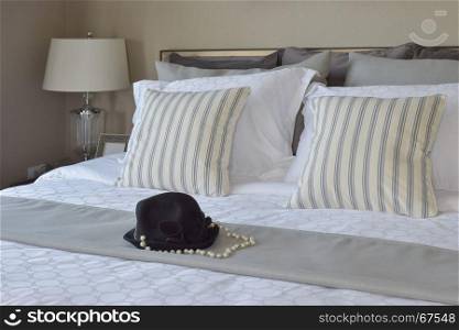modern bedroom with striped pillows and black hat on bed