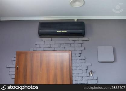 modern black air conditioner hanging on white brick wall. High quality photo.. modern black air conditioner hanging on white brick wall. High quality photo