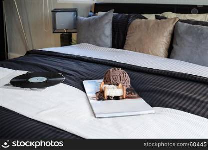 modern black tone bedroom decorative with book, crochet and gramophone record on bed