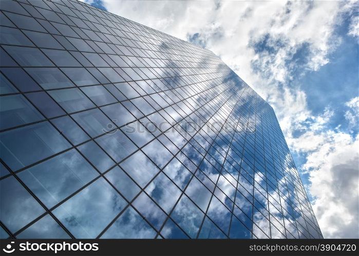 Modern building with reflection of blue sky and clouds