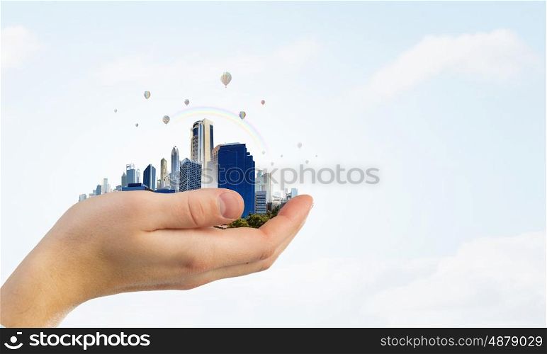 Modern buildings and landmarks. Close up of hands holding image of modern cityscape