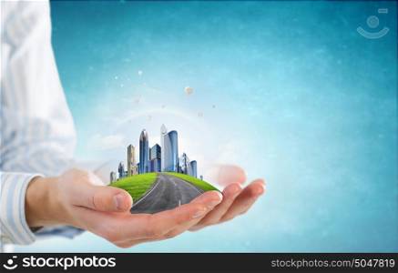 Modern buildings and landmarks. Close up of hands holding image of modern cityscape
