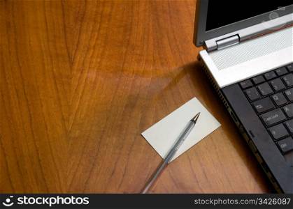 Modern business desk with laptop pen and business card