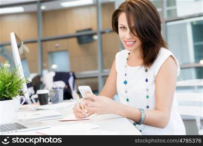 Modern business woman in the office with mobile phone. Modern successful business woman