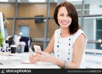 Modern business woman in the office with mobile phone. Modern successful business woman