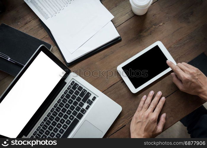 Modern businessman with tablet computer reading news and work report document at morning in cafe.