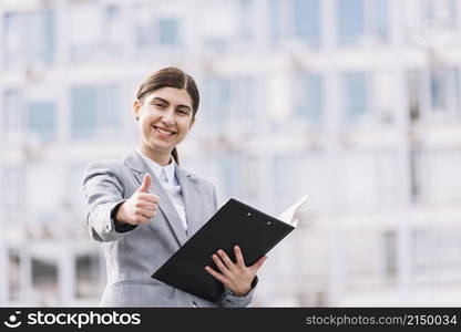 modern businesswoman with clipboard outdoors