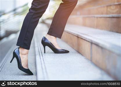 modern businesswoman working woman close up legs walking up the stairs in modern city in rush hour to work in office a hurry. During the first morning of work. Leave space for writing descriptive text