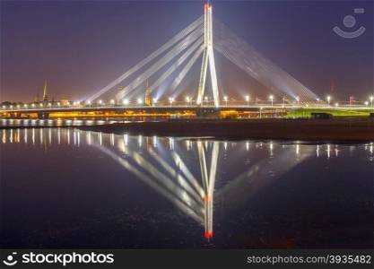 Modern cable-stayed bridge across the Daugava River in Riga night.. Riga. Cable-stayed bridge.
