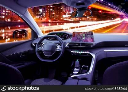 Modern car cockpit interior in night traffic, navigating or autonomous driving concept
