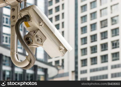 Modern cctv camera is hanging neart the office building area.