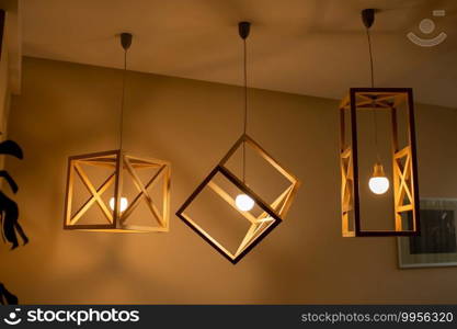 Modern ceiling lights bulbs l&made of wooden frame geometric shape interior and loft style decorating with white wooden wall.. Modern ceiling lights bulbs l&made of wooden frame geometric shape interior and loft style decorating with white wooden wall