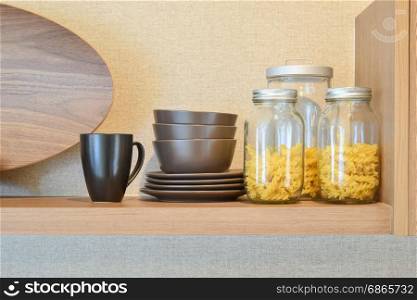 modern ceramic kitchenware and utensils on pantry shelf