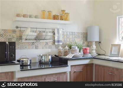 modern ceramic kitchenware and utensils on the black granite countertop