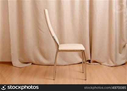 Modern chair standing in front of curtains background