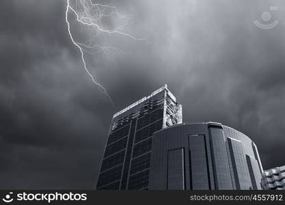 Modern city. Bottom image of skyscraper with thunder lightning in sky