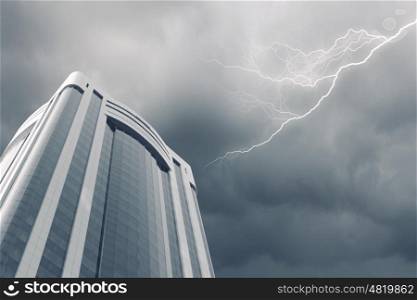 Modern city. Bottom image of skyscraper with thunder lightning in sky