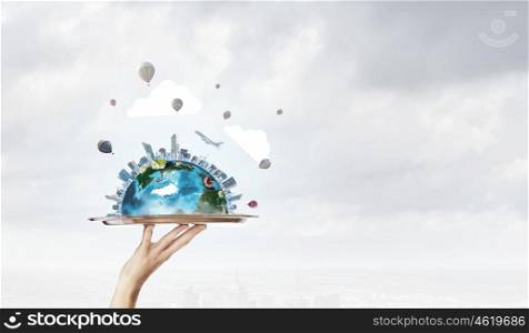 Modern city model. Hand holding metal tray with modern cityscape. Elements of this image are furnished by NASA