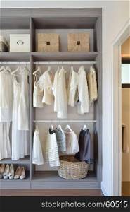 modern closet with row of white dress and shoes hanging in wardrobe
